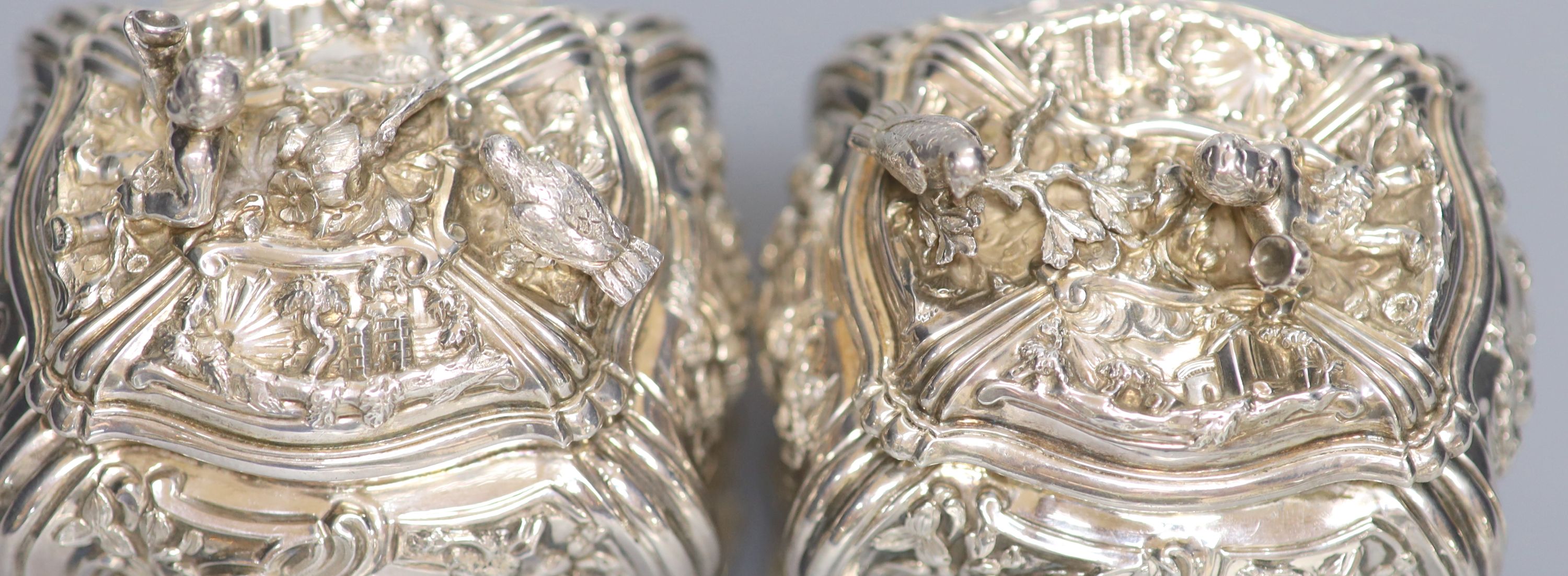 A good pair of George II embossed silver tea caddies and covers, by Elizabeth Godfrey, London, 1749/50, housed in a later 19th century pierced Canton ivory mounted caddy, with velvet interior